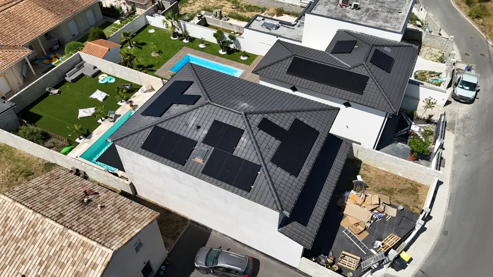Maison à étage de Cenon, panneaux photovoltaïques noirs sur un toit complexe, vue de drone